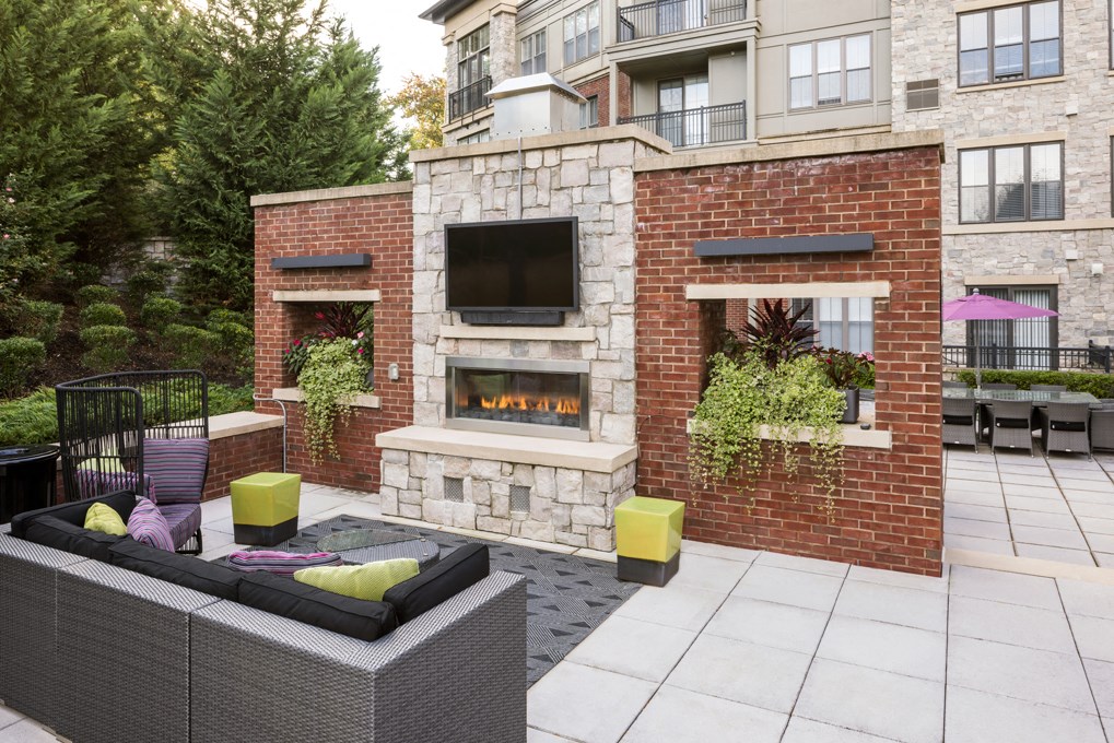 the outdoor patio has a fireplace and a seating area