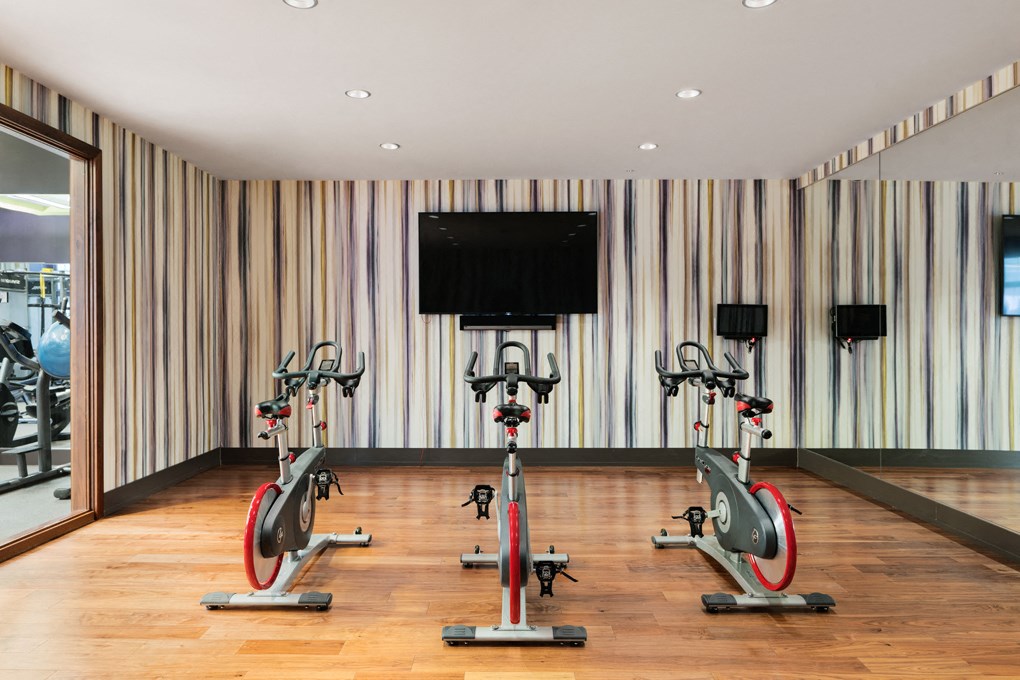 a group of exercise bikes in a room with a tv