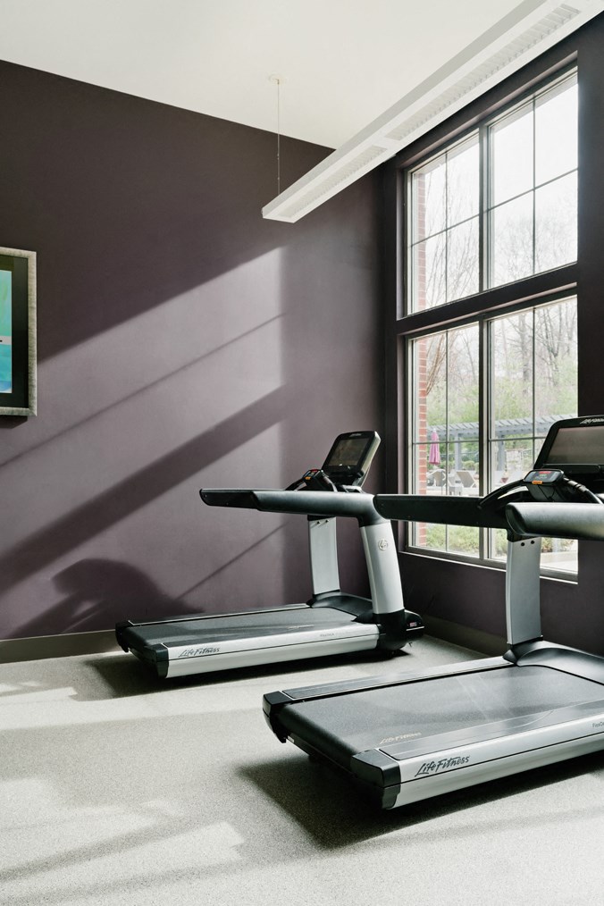 two treadmills in a workout room with a window