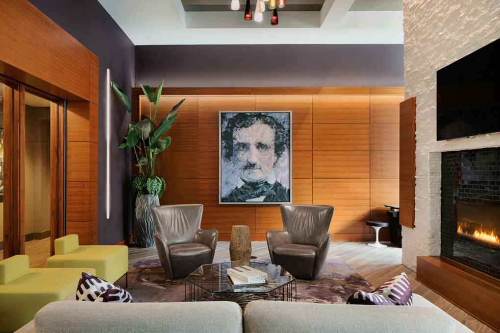 a living room with a fireplace and a painting of a man