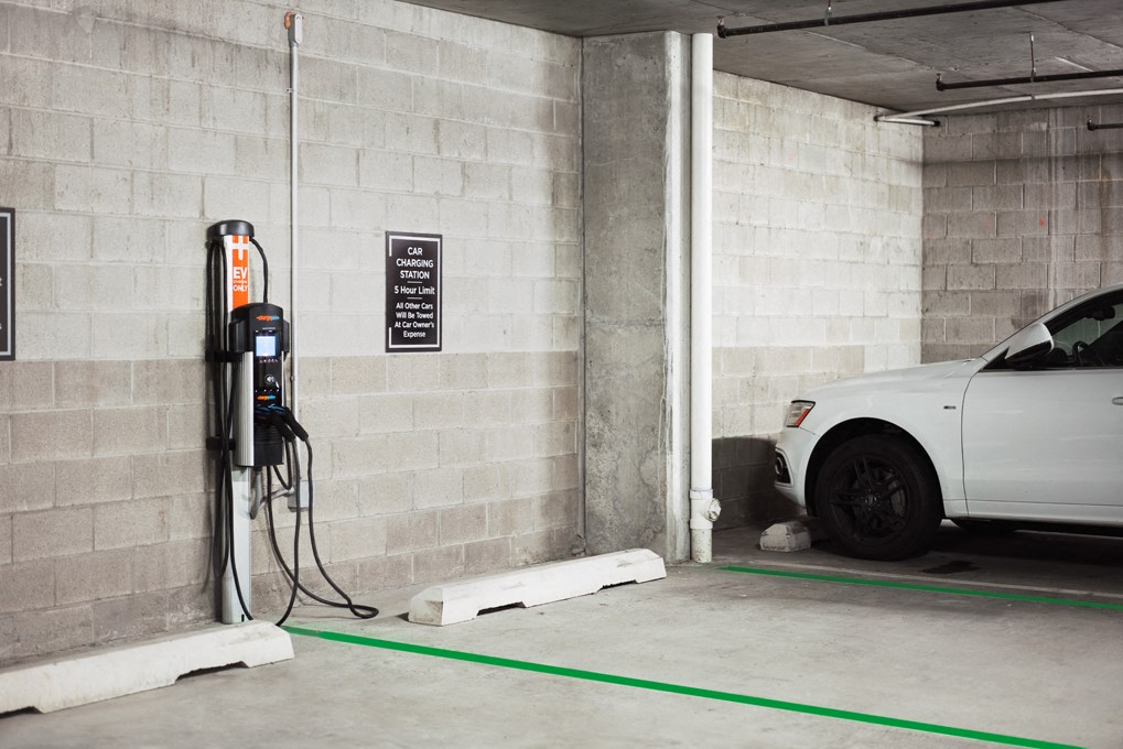 a white car parked at a gas pump in a parking garage