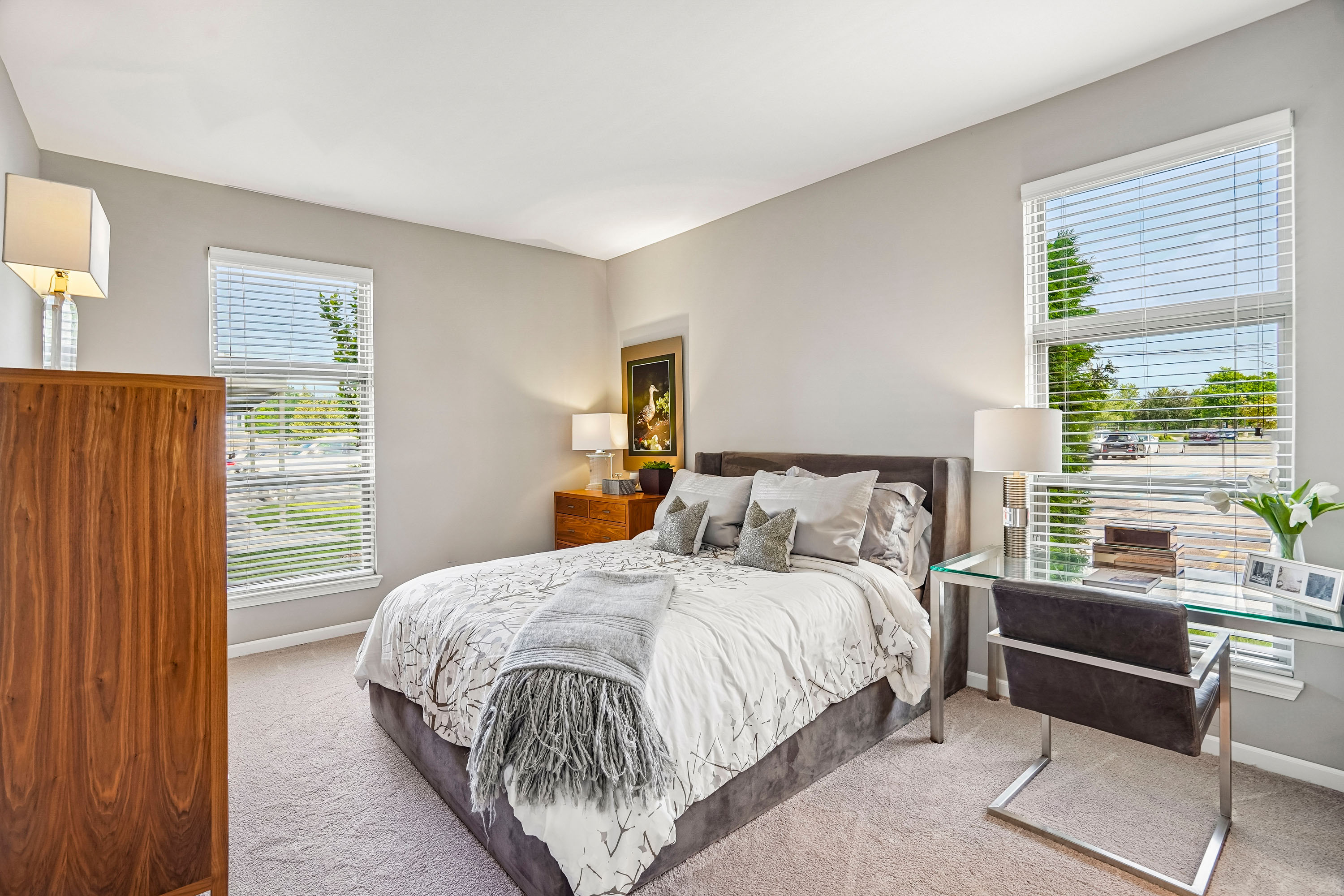 A bedroom with a bed, desk, and chair.