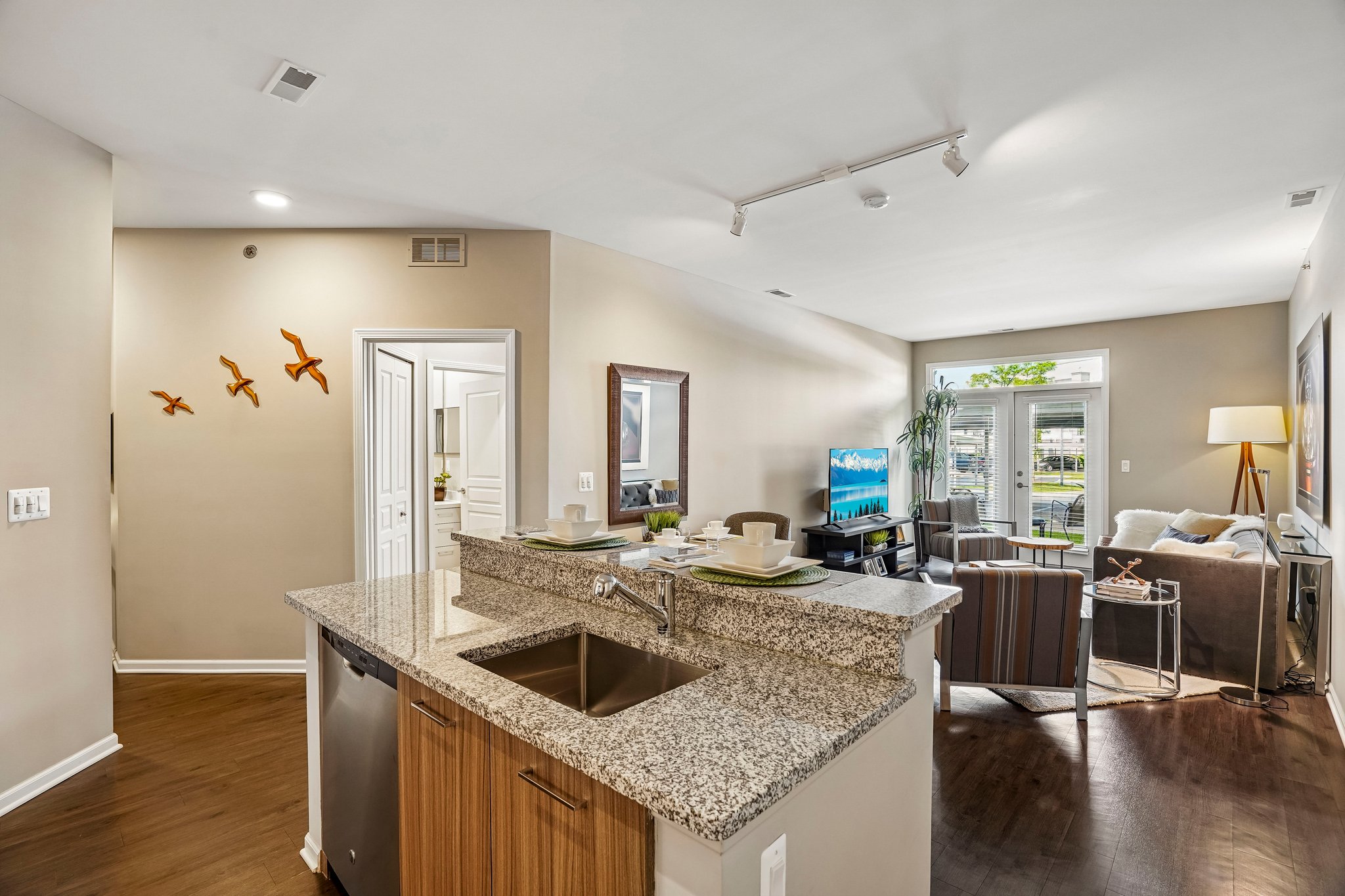 A kitchen with a granite counter top and wooden cabinets.