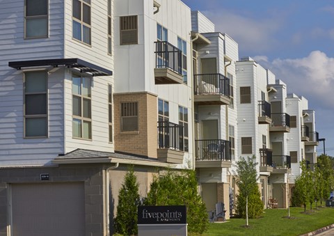 an exterior view of an apartment building with balconies and a garage
