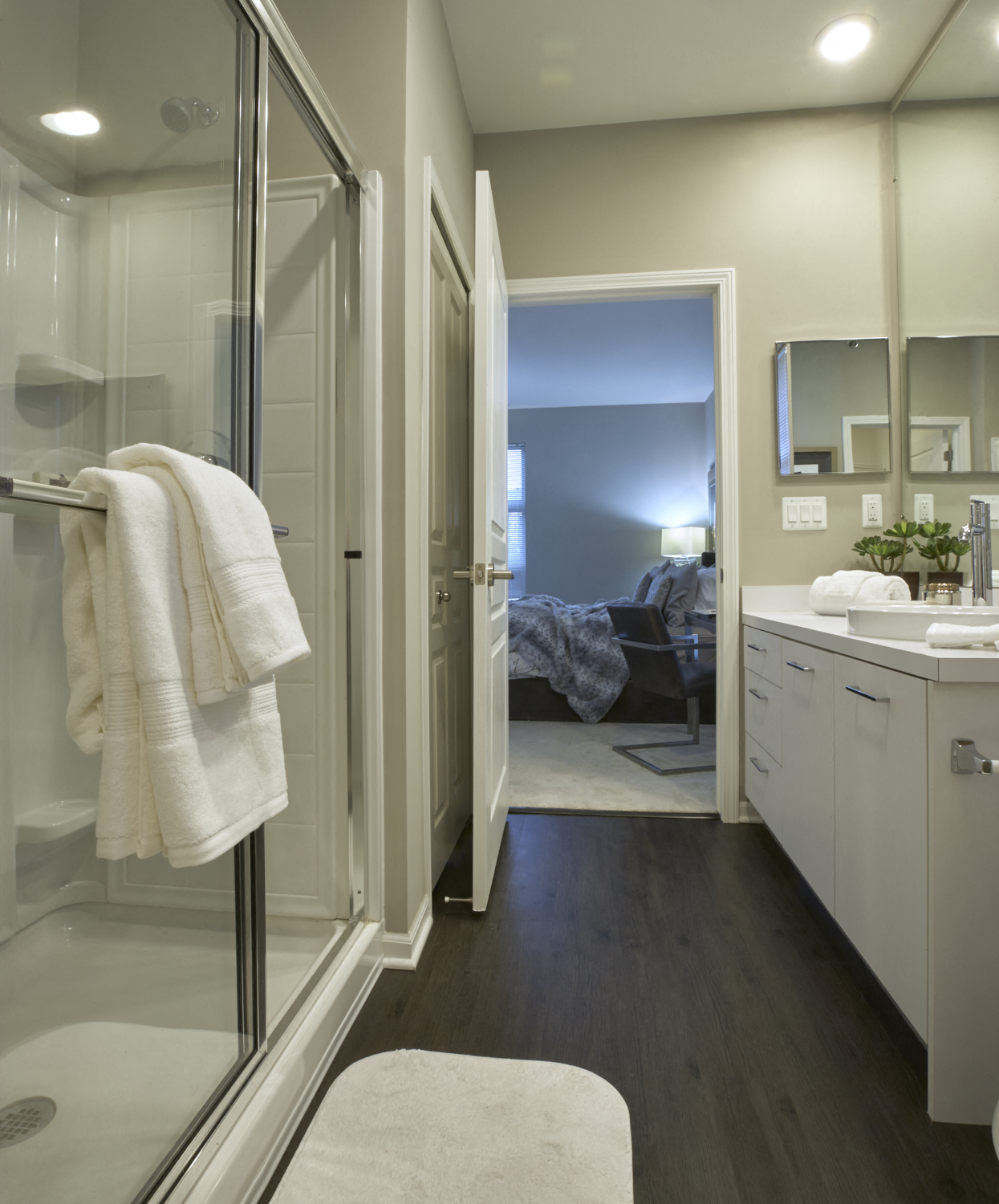 a bathroom with a shower and a sink and a bed