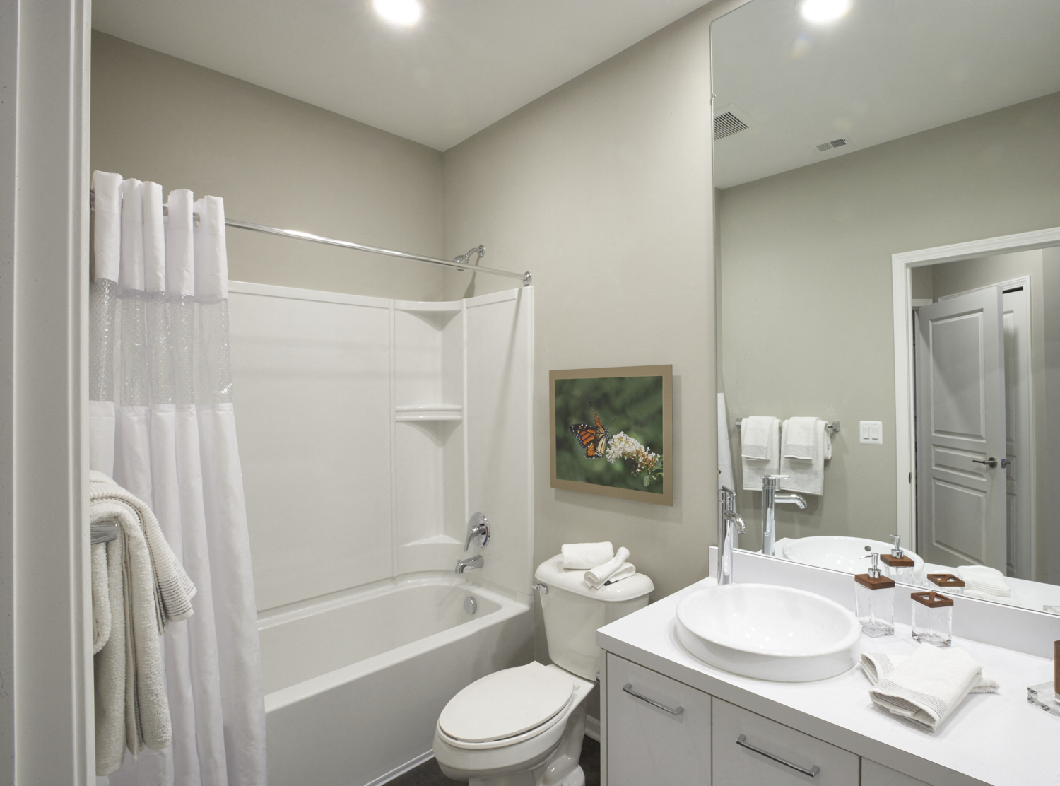 a bathroom with a tub sink and toilet and a mirror