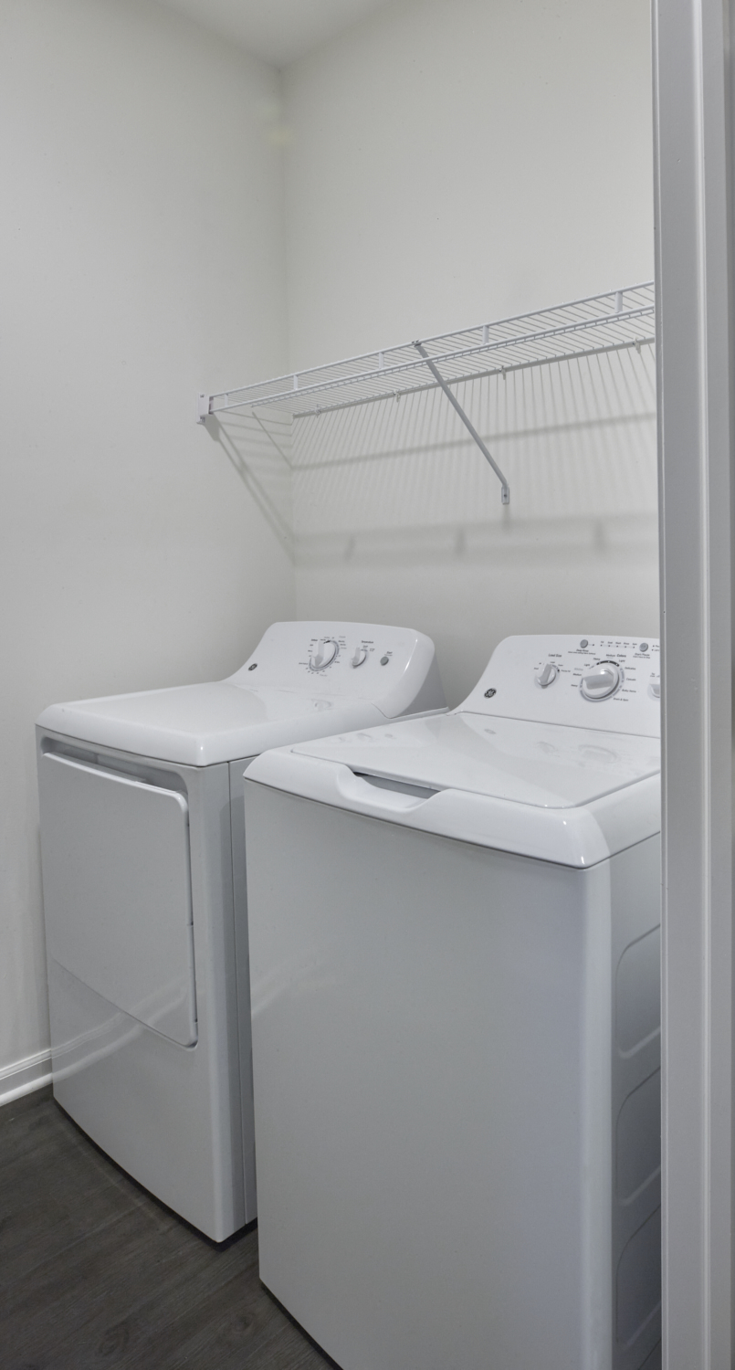 an empty laundry room with two washes and a dryer