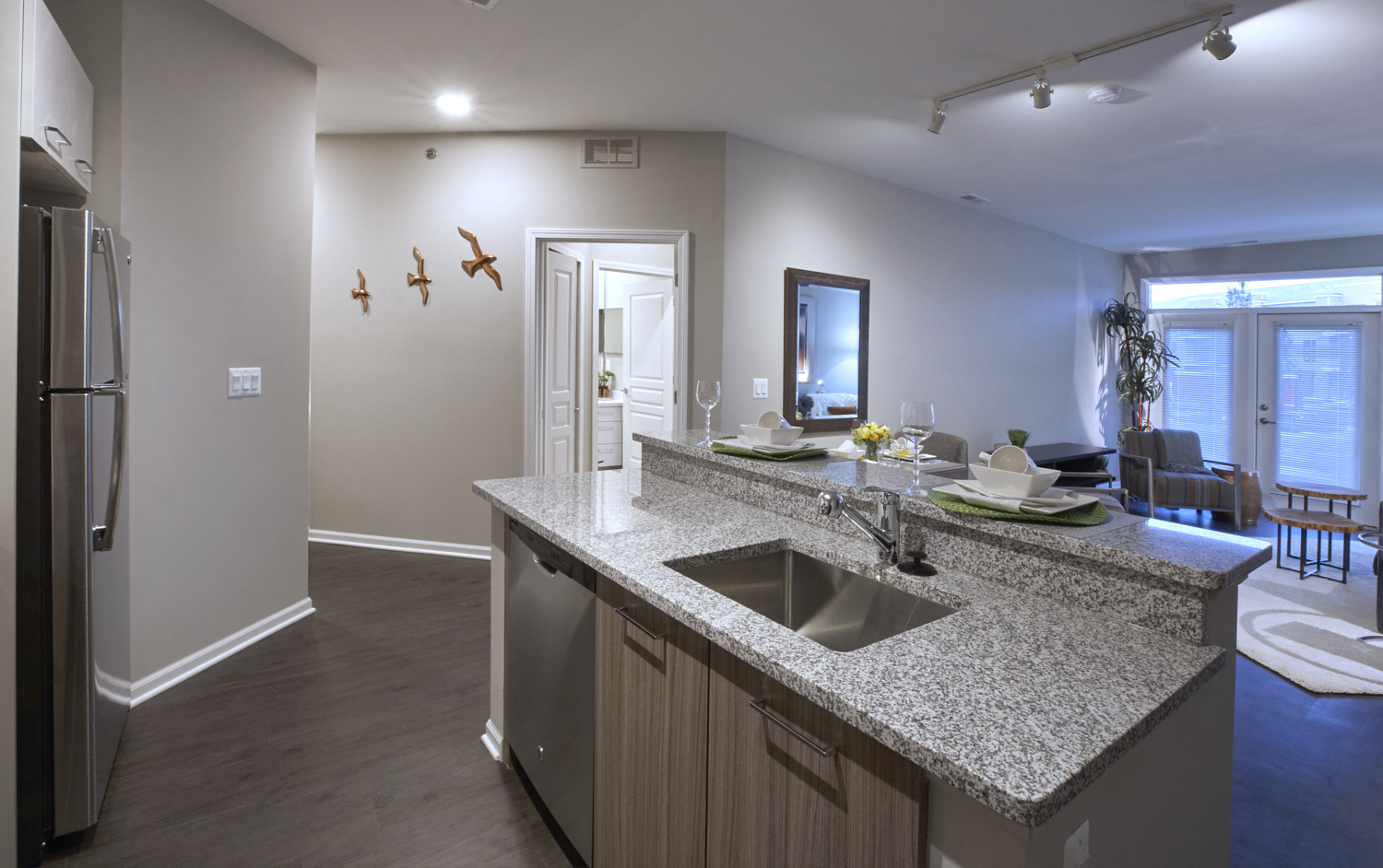 an open kitchen and living room with a granite counter top
