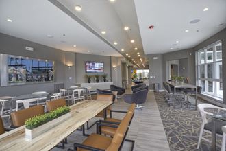 a communal area with tables and chairs and a television