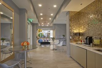 a lobby with tables and chairs and a coffee bar and a window