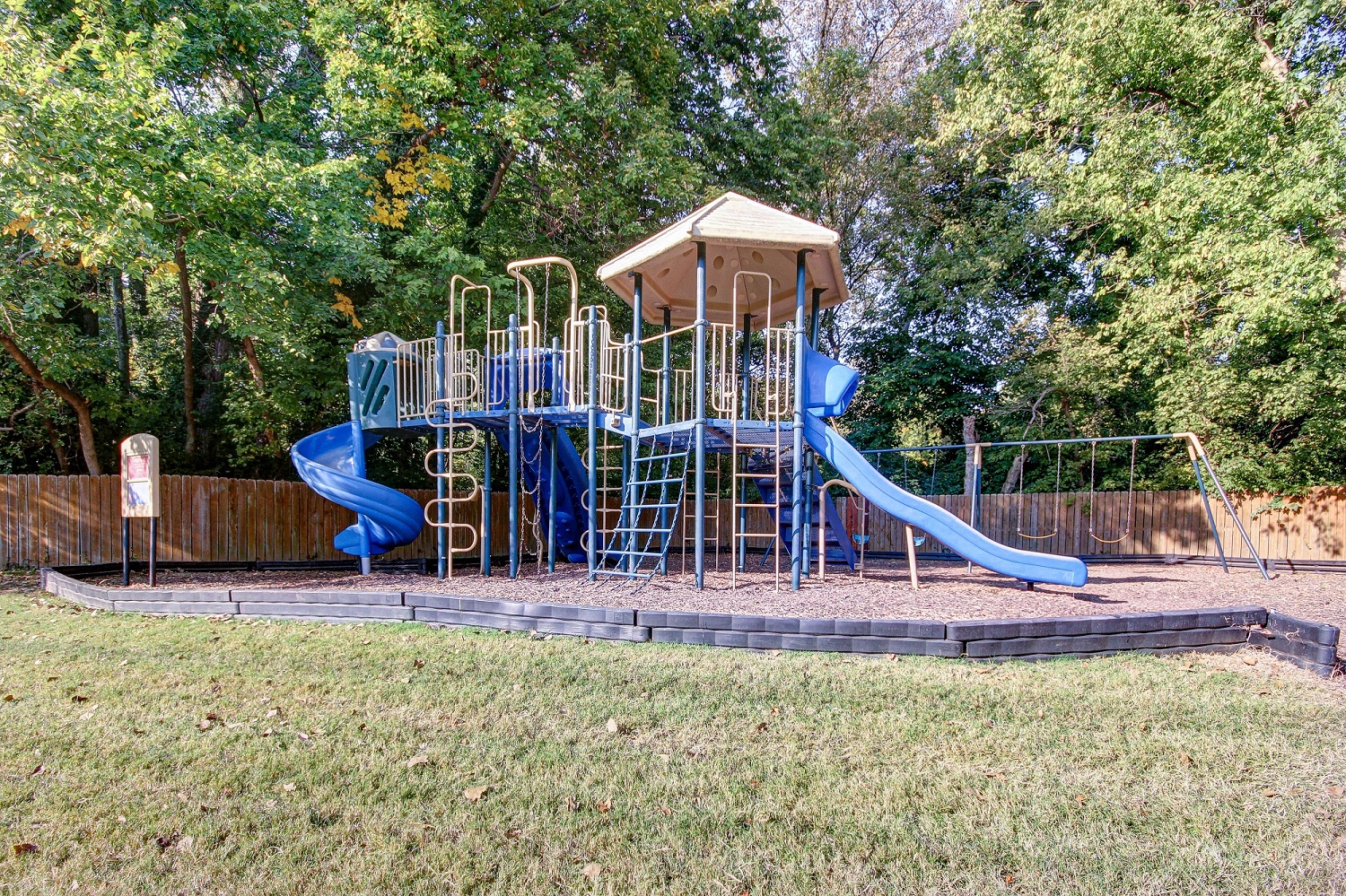 a playground with a playset and slides in a park
