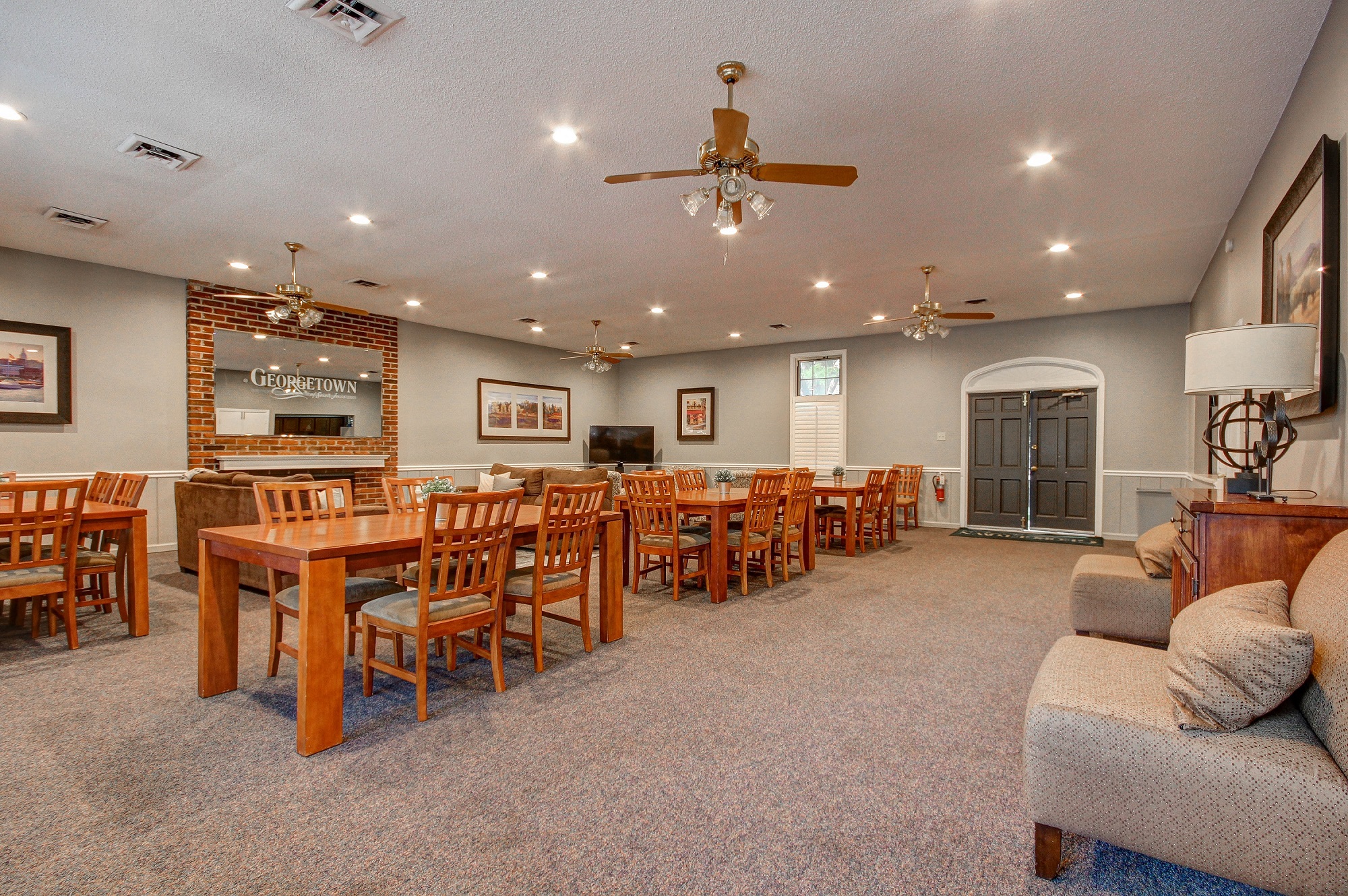 a large living room with tables and chairs and a fireplace