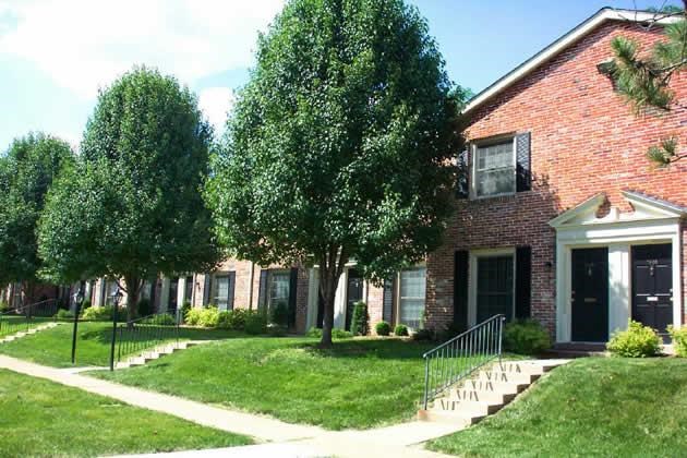a red brick house with trees in front of it