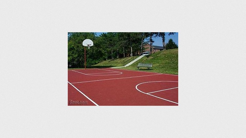 a red basketball court with a bench
