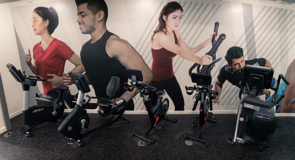 a group of people working out on exercise bikes in a gym