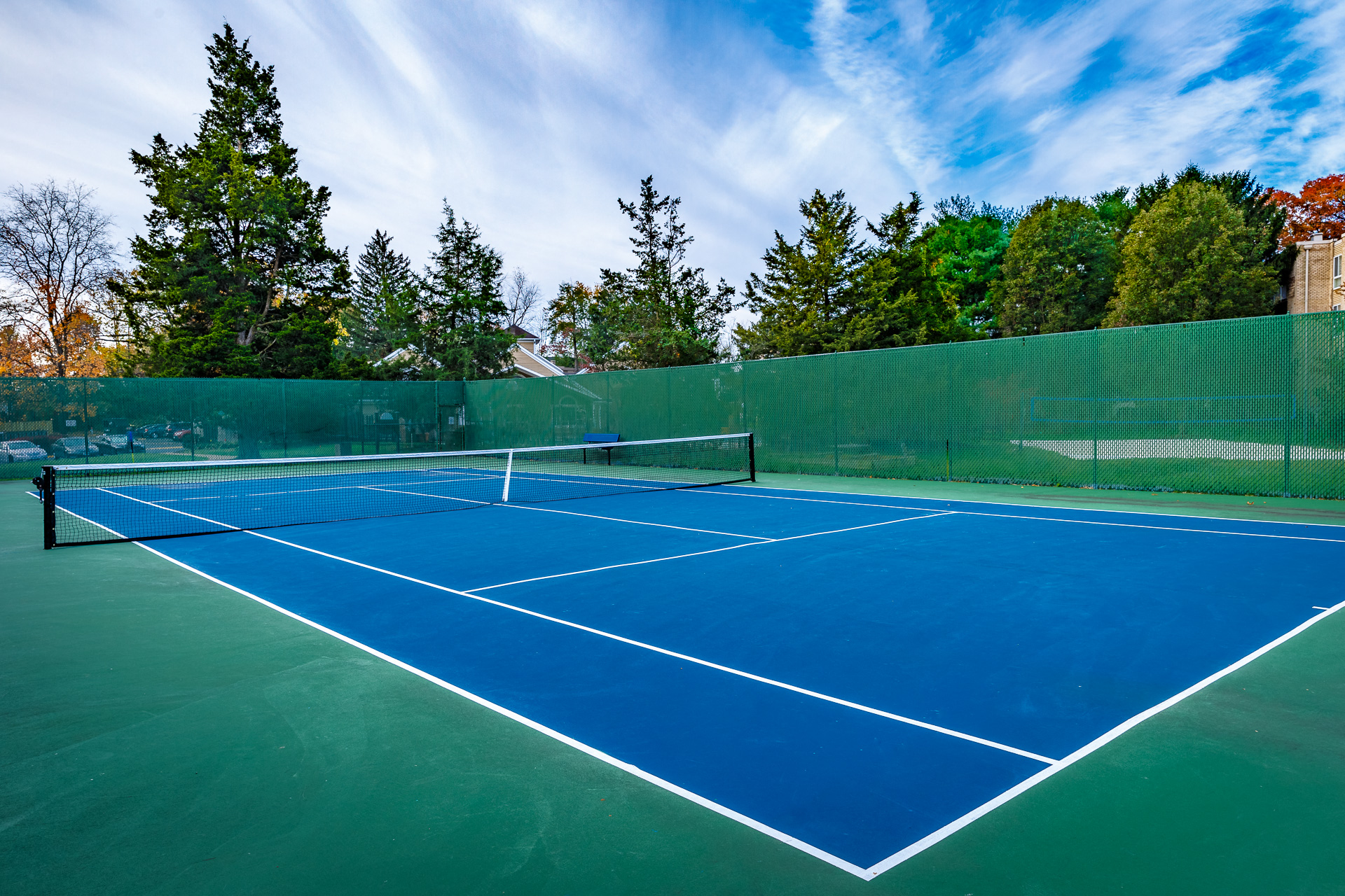 a tennis court with blue and green courts and a green fence