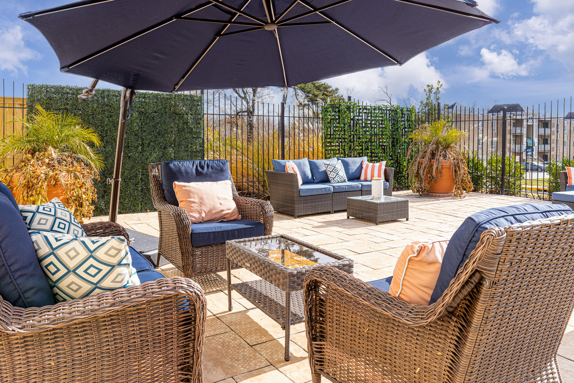 the patio is furnished with wicker furniture and an umbrella