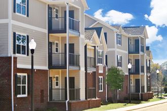 a row of townhomes with brick and siding and balconies
