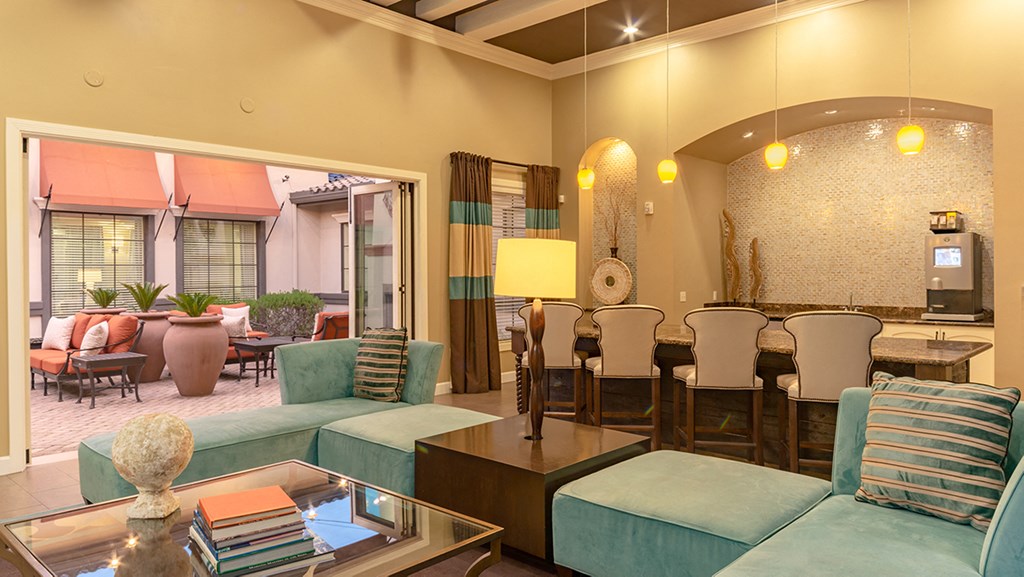 a living room with blue couches and chairs and a dining room with a table and chairs