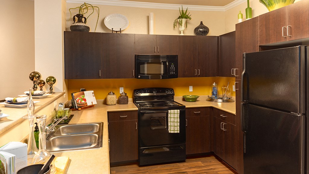 a kitchen with black appliances and brown cabinets