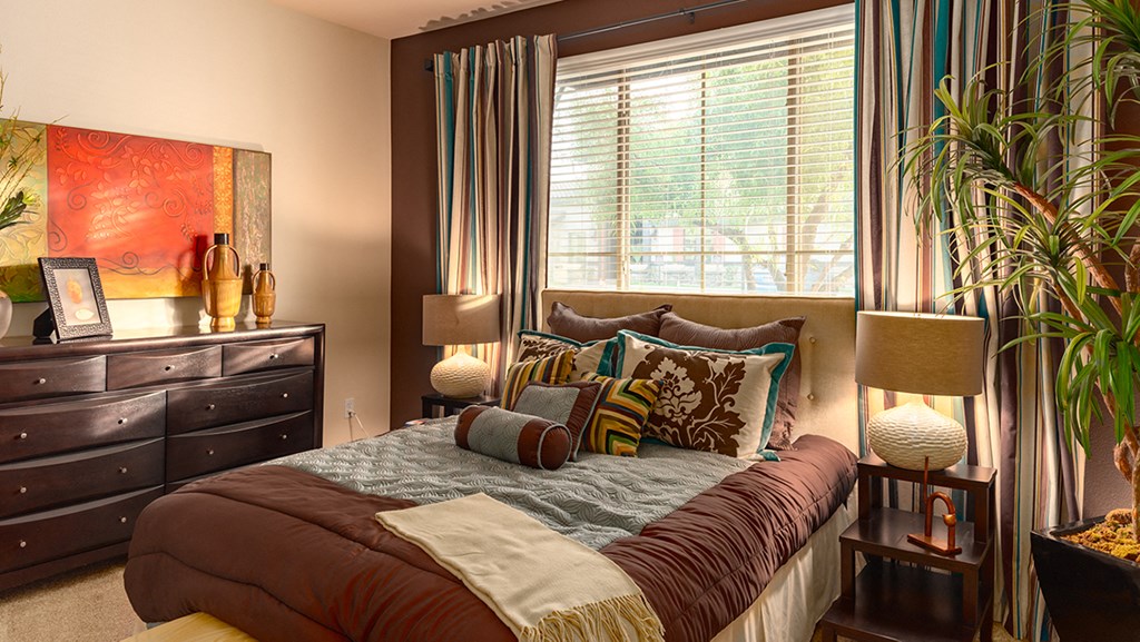 a bedroom with a large bed in front of a large window