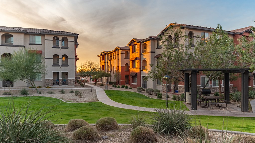 a group of houses in a row with a sunset in the background