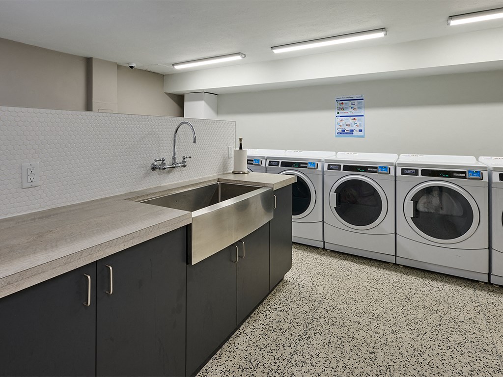 a washer and dryer area in a laundry room with a sink and was