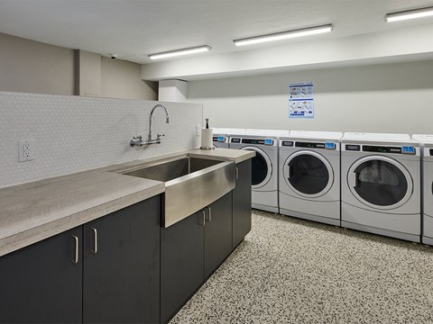 a washer and dryer area in a laundry room with a sink and was