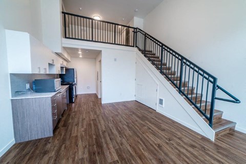 a view of a living room with a staircase and a kitchen