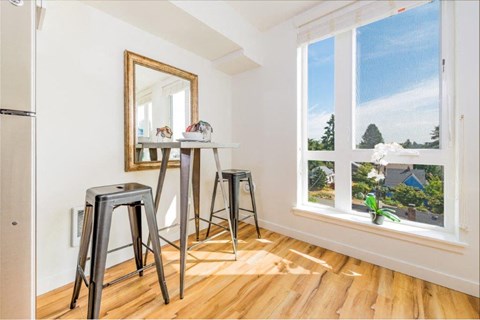 a living room with bar stools and a large window