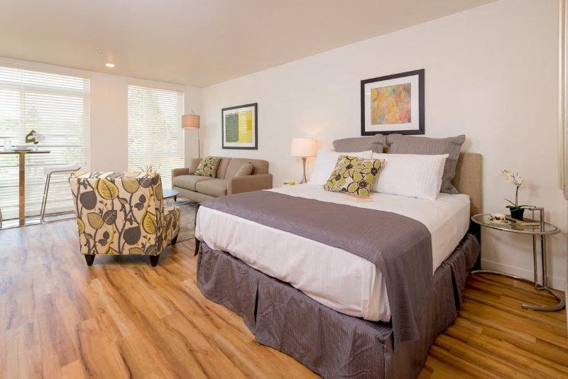 a bedroom with a bed and a couch and a chair