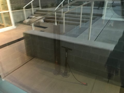 A staircase with a glass railing and a black base.