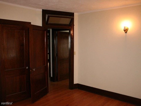 an empty room with wooden doors and a light on the wall