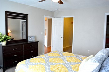 Bedroom with queen size bed, dresser, mirror, and walk-in closet - Photo Gallery 3