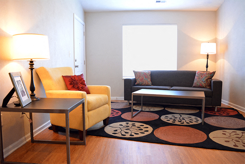 Living room with couch, chair, coffee table, sides tables, and two standing lamps
