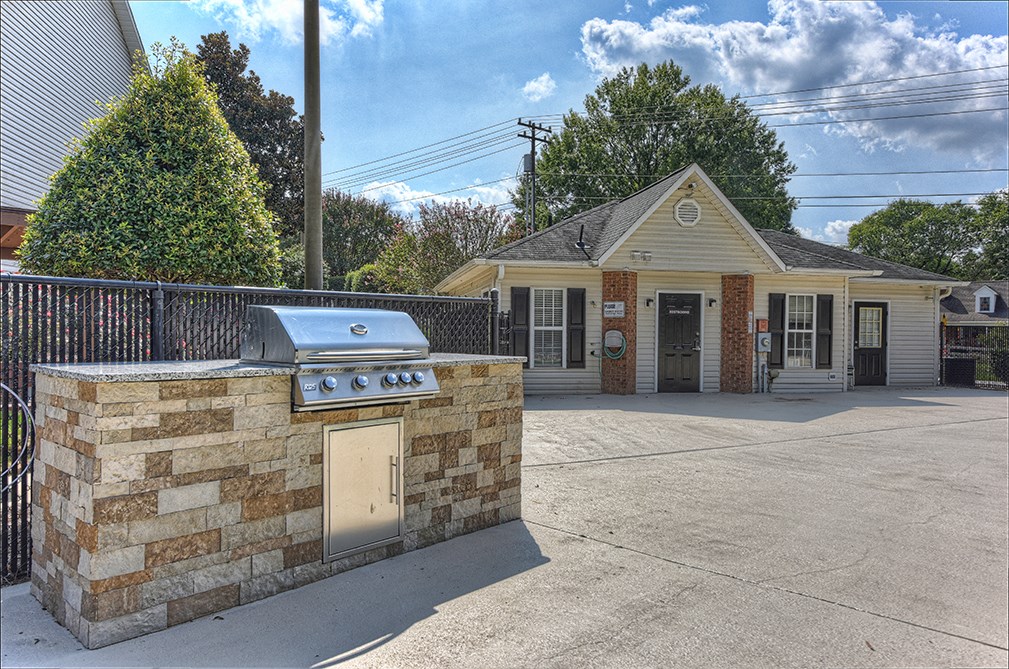a gas barbecue grill in front of a small house