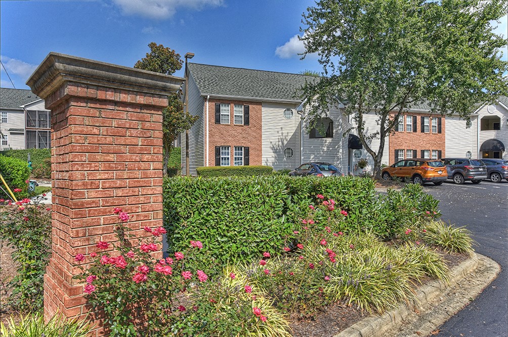 a brick wall in front of an apartment building with flowers