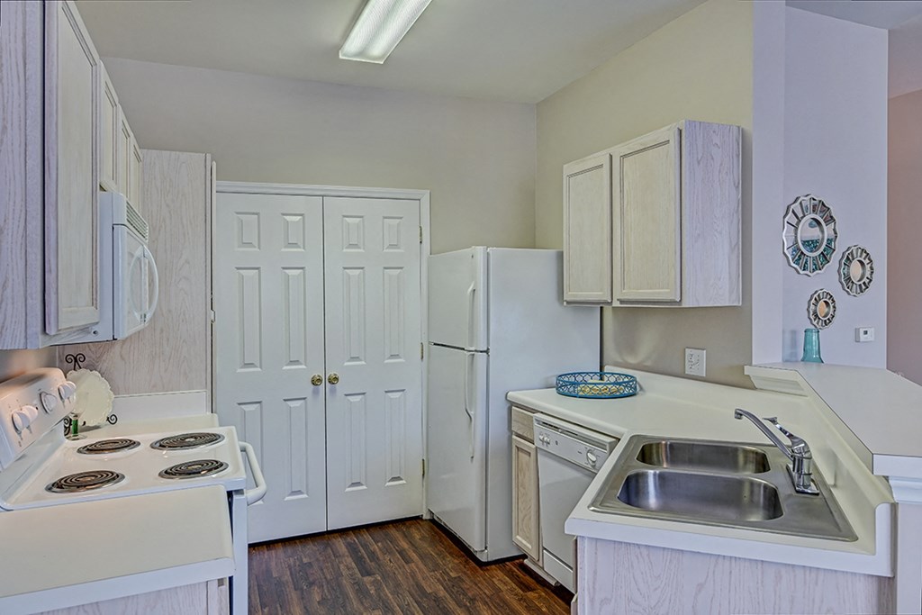 a kitchen with white cabinets and a sink and a refrigerator