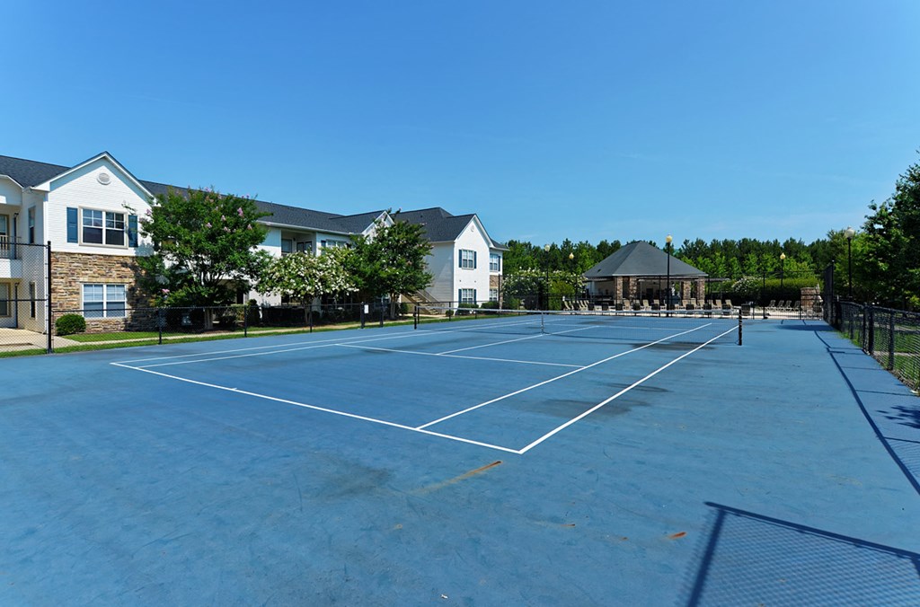a tennis court with houses in the background