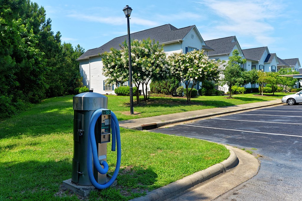 a parking meter in the grass in front of a house