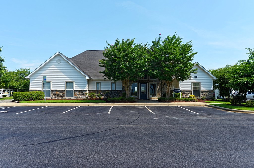 a white house with a parking lot in front of it