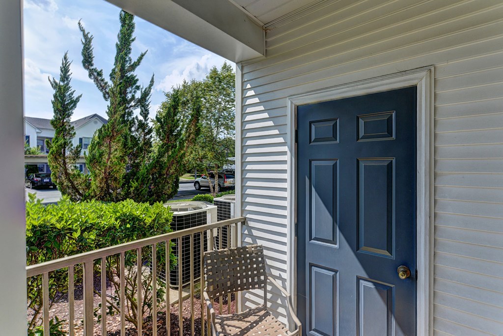 the front door of a house with a blue door and a balcony