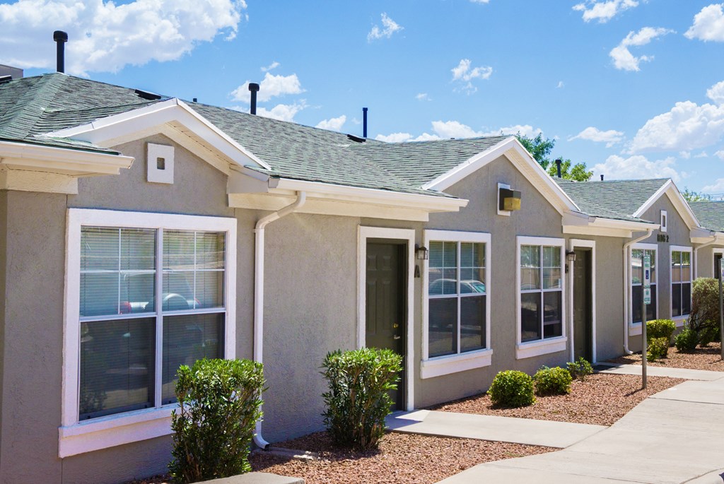 a beige house with a sidewalk in front of it