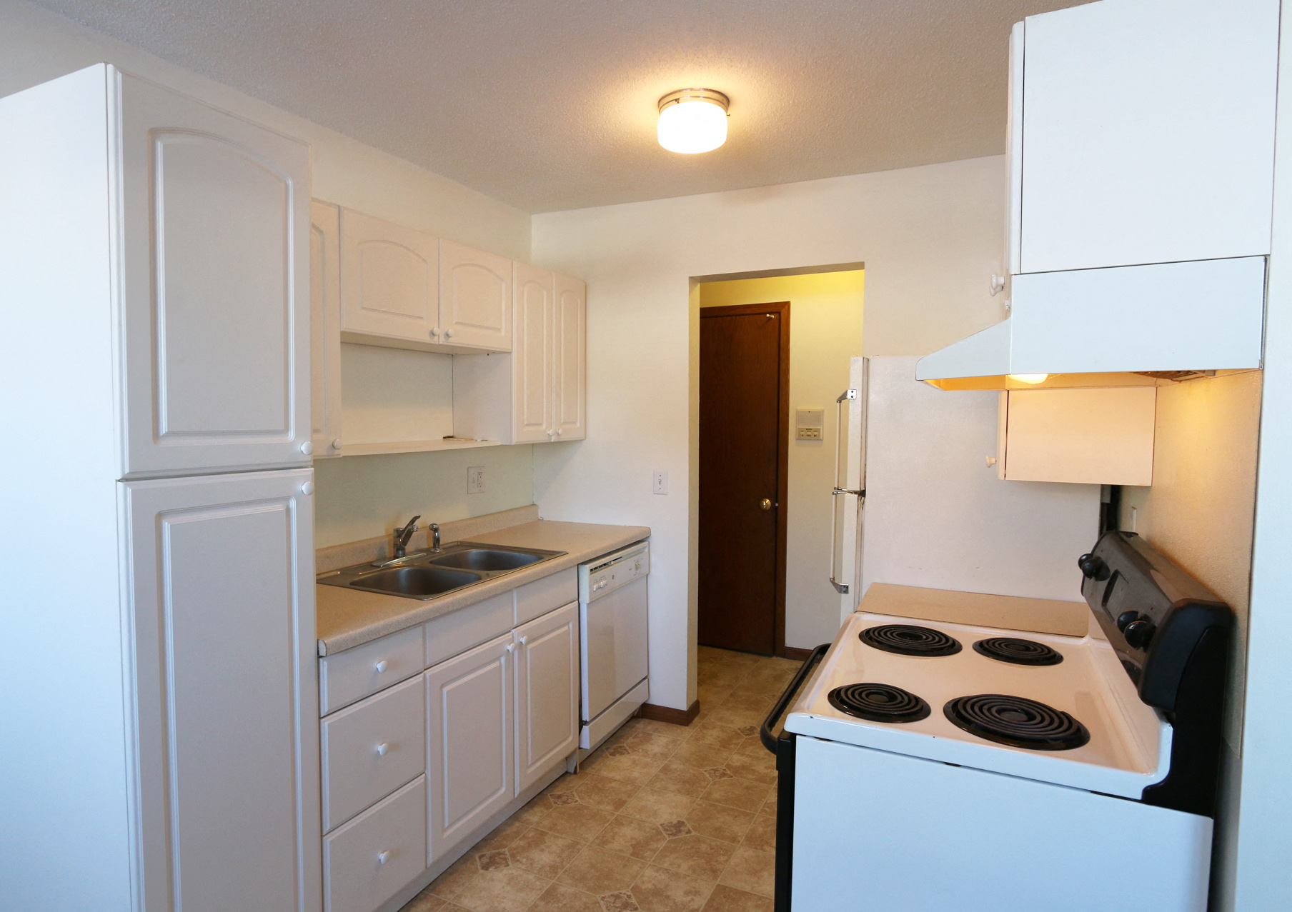 a kitchen with a stove and a sink and a refrigerator