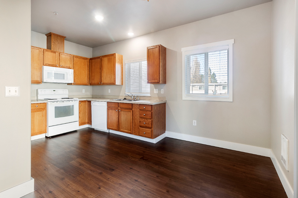 an empty kitchen with wooden floors and wooden cabinets