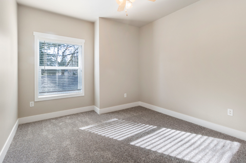 an empty room with carpet and a window