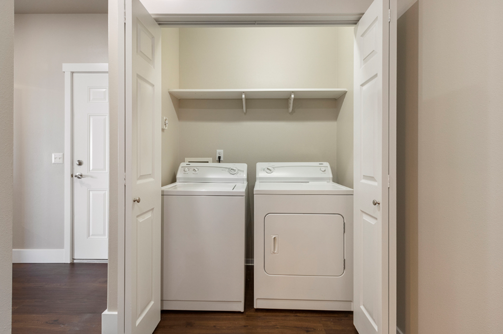 an empty laundry room with two washes and a dryer
