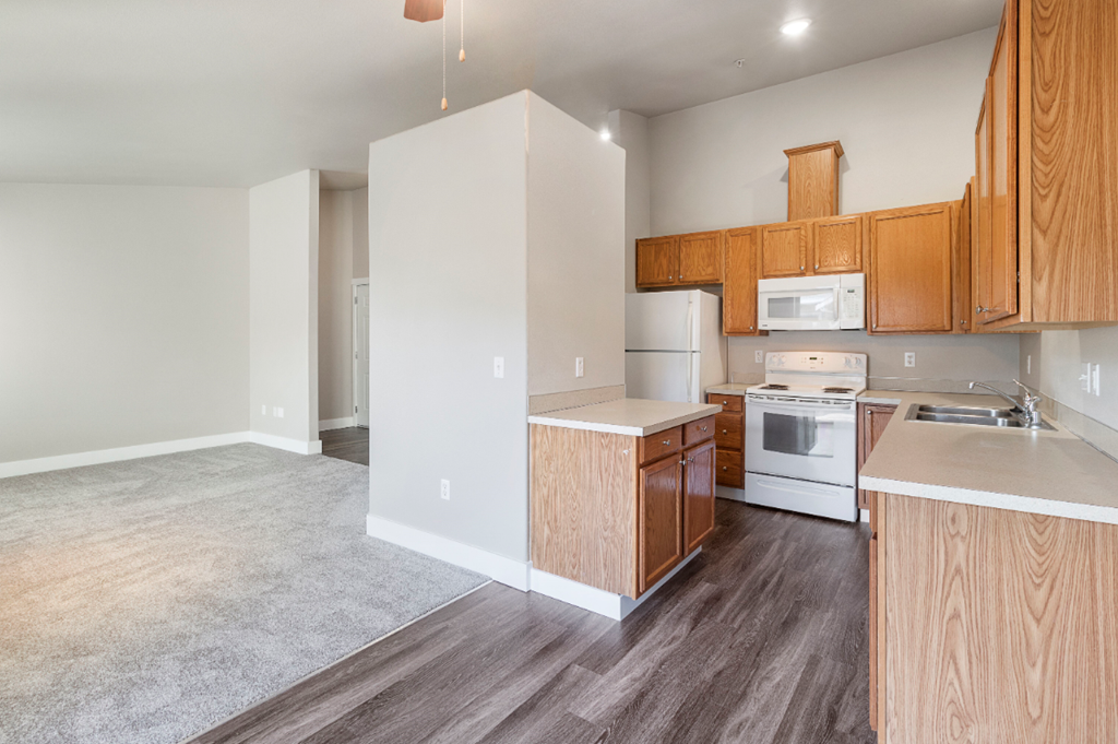 an empty kitchen with wooden cabinets and white appliances