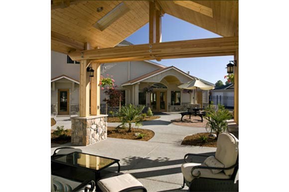 a patio with chairs and a table in front of a house
