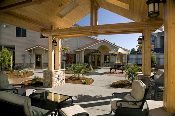 a patio with chairs and a table in front of a house